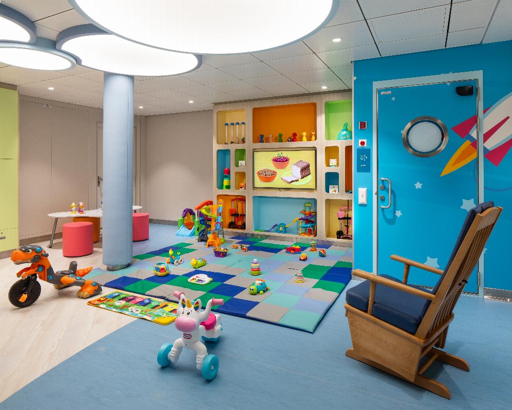 Nursery play space with soft mats, toys and a rocking chair