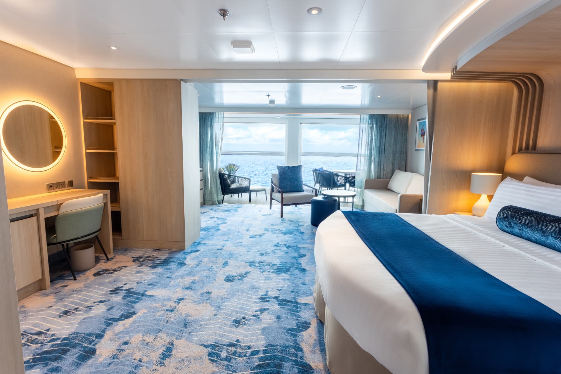 Infinite Grand Suite on Legend of the Seas with king bed, lounge seating and a glass infinite balcony