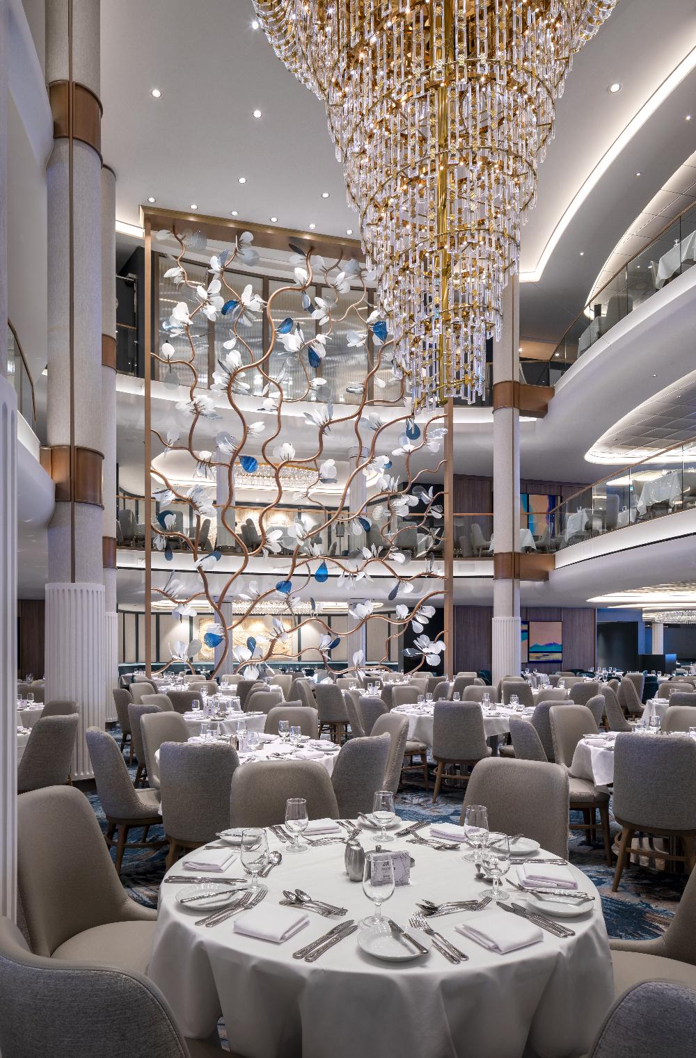 Three-storey Main Dining Room with crystal chandelier and floral sculpture on Legend of the Seas