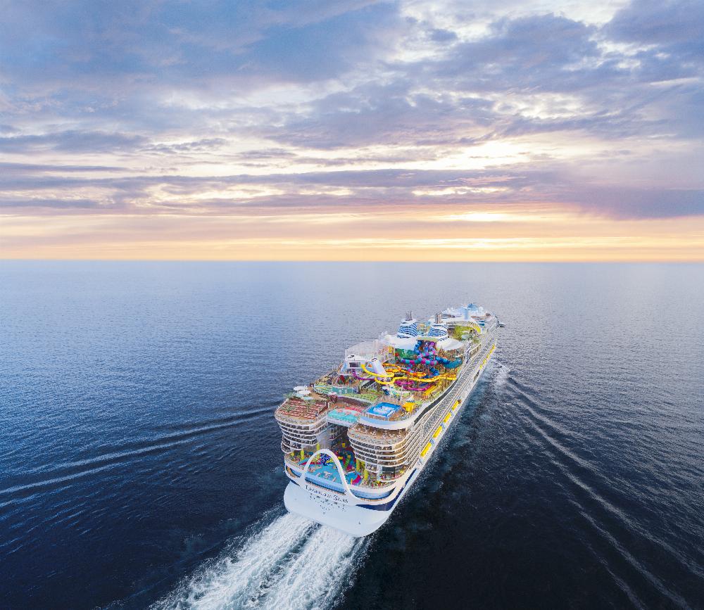 Aerial view of Legend of the Seas cruising open ocean under a pastel sunset