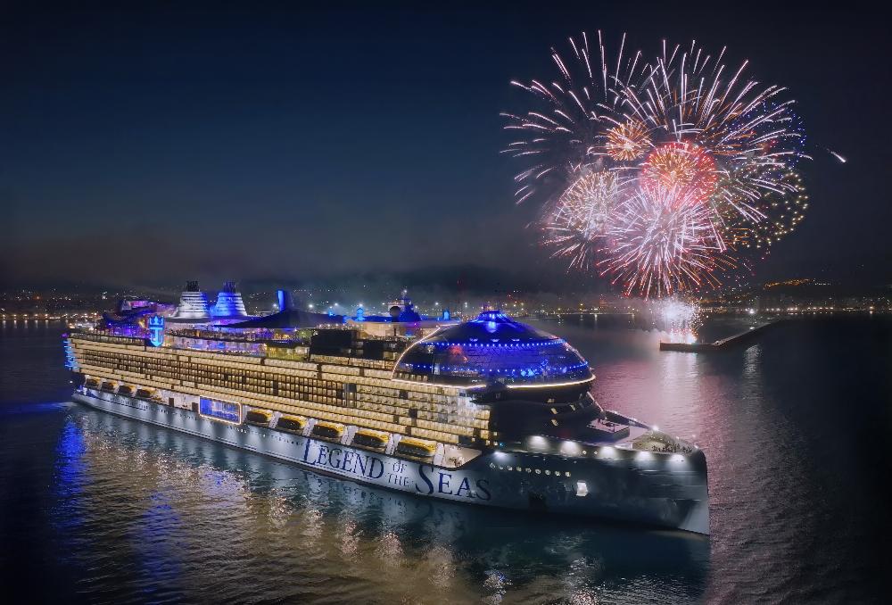 Legend of the Seas lit up at night beneath a fireworks display in Málaga